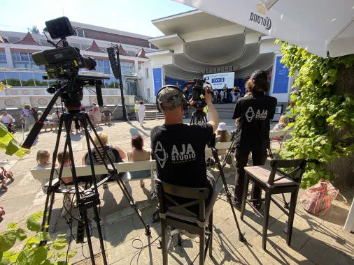 Operatorzy AJA Studio przy kamerach na wydarzeniu plenerowym przed sceną